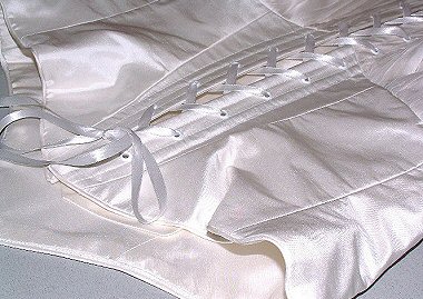 Ribbon lacing on back of Art Nouveau style white silk wedding corset. 