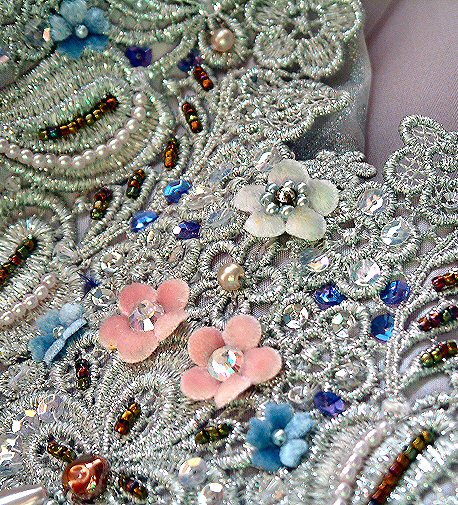 detail of silver lace encrusted with crystals, pearls, sequins