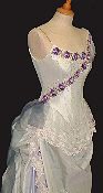 Asymmetrically decorated wedding dress with draped skirt, antique lace and corsetted bodice.