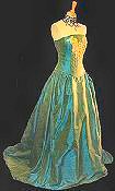 This classic glamorous gown with strapless boned bodice is embellished with gold lace, crystal drops and beading.  It has an unashamedly romantic full skirt and is laced at the back to emphasize the waist.  Made-to-measure in literally hundreds of colour and fabric variations. Shown above in a shot green/blue shade.