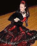 A stunning costume of vividly contrasting colours highlighted in gold. The bodice of red silk and black velvet is cut to professional dance costume standards to allow for complete freedom of movement. The skirt of tiered layers of black lace is edged in gold with red ribbon highlights and has adequate volumes of fabric to accomodate the most expansive choreography. This costume is equally suitable for Flamenco, character dance or attending a Masked Ball in typically Spanish style.
